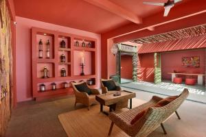 a living room with red walls and chairs and a table at PinkCoco Gili Trawangan - for Cool Adults Only in Gili Trawangan