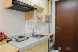 a kitchen with a sink and a counter top at Comfy Cozy Studio in BSD in Babakan