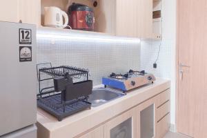 タンゲランにあるRestful and Cozy Living Studio Apartment at B Residence By Travelioのシンクの上に乾燥ラックが付いたキッチン