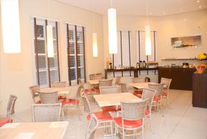a restaurant with tables and chairs and a kitchen at Hotel Castro Mendes in Campinas