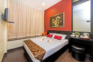 una habitación de hotel con una cama con dos platos de comida. en Hotel 81 Kovan en Singapur