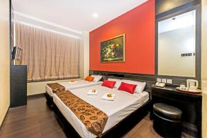 a hotel room with a large bed with red walls at Hotel 81 Kovan in Singapore