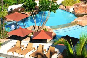 a pool with chairs and umbrellas in front of it at Timberland Highlands Resort in San Mateo