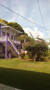 a purple house with a porch and a yard at Sea View in Little Corn Island