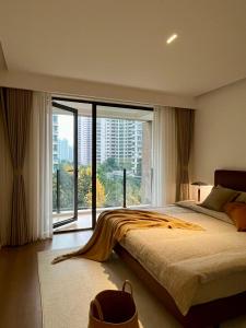 um quarto com uma cama grande e uma janela grande em Sunny Abode 中远A 2Bedroom river view near Suzhou River em Xangai