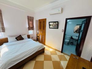 a bedroom with a bed and a bathroom with a toilet at Phú Mỹ hotel in Nam Ðịnh