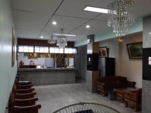 a lobby with a bar and some chairs and chandeliers at Singapore Hotel in Hat Yai