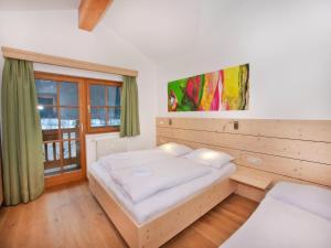 een slaapkamer met een bed en een groot raam bij Apartment in Wald near Ski Slopes in Wald im Pinzgau