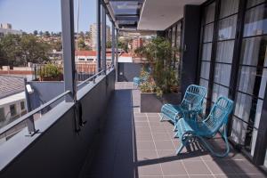 two blue benches on the balcony of a building at Savoy Double Bay Hotel in Sydney