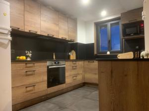 a large kitchen with wooden cabinets and a window at Appartement 78m2 pied des pistes in Les Angles