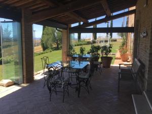 un patio con mesas, sillas y ventanas en Podere Fornaci, en Asciano