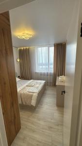 a bedroom with a bed and a large window at АК Апартамент in Kirovo