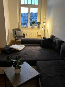 a living room with a black couch and a table at Boardinghouse Plauen im Zentrum der Stadt in Plauen