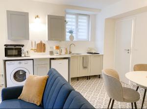 a living room with a blue couch and a kitchen at Gold Touch Studio in Timişoara