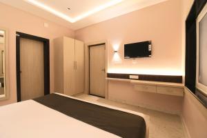 a bedroom with a bed and a flat screen tv at Hotel Sai Swastik in Puri