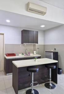 a kitchen with two bar stools and a counter at D'Loft 7 Homestay in Kota Kinabalu +1 photo