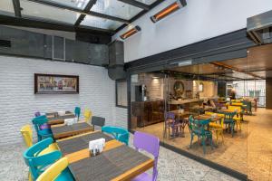 a restaurant with wooden tables and colorful chairs at Tulip City Hotel & Spa - Istanbul Taksim Pera City Center in Istanbul