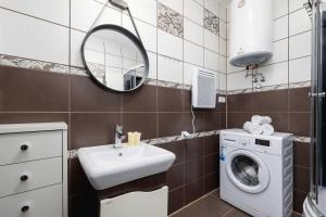 Un baño con lavadora y lavabo. en Bright Studio with Balcony in Murzasichle by Noclegi Renters, en Murzasichle