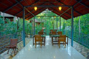 a table and chairs under a pavilion with a table and chairs at Snow Hills Resorts in Thekkady
