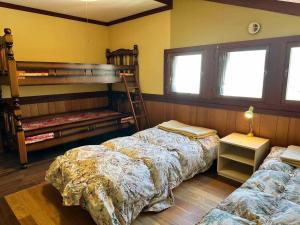two beds in a room with two bunk beds at ハノイペンション in Higashi-gumi