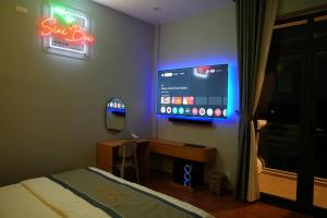 a bedroom with a bed and a tv on the wall at Siri 2 Hotel in Mỹ Tho