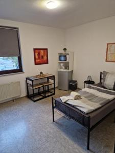 a bedroom with a bed and a table and a window at Zimmer A in Mönchengladbach