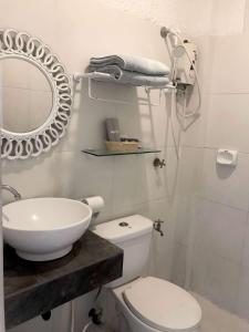 a bathroom with a sink and a toilet and a mirror at Casa Bahia Dive Resort in Bagalañgit