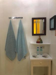 a bathroom with two towels hanging on a wall at Casa Bahia Dive Resort in Bagalañgit