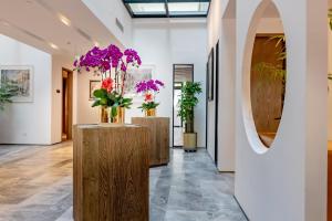 un corridoio con fiori viola in vasi su un tavolo di 北京方庄万信至格酒店 a Pechino Altre 7 foto