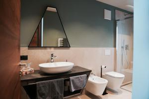 a bathroom with a sink and a toilet and a mirror at Aktiv Lodge Meran - Terrace Large in Saltusio +32 photos