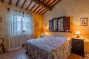 a bedroom with a bed and a large window at Podere Montechiari - App Nonna & Maria in Montalcino
