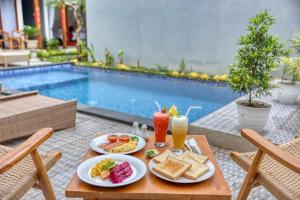 a table with food and drinks next to a pool at Lavanya Villa in Nusa Penida
