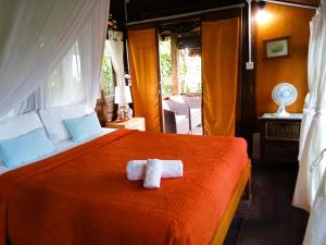a bedroom with a bed with two towels on it at Pondok Pisces Bungalows Balian Beach in Selemadeg