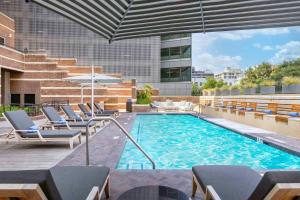奥斯汀DoubleTree Suites by Hilton Austin Downtown Capitol的一座带椅子和遮阳伞的游泳池
