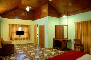 a room with a bed and a tv in it at Snow Hills Resorts in Thekkady
