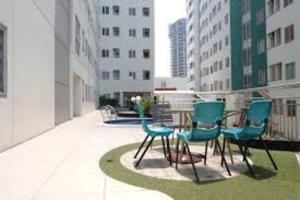 a group of chairs and a table on a balcony at Pavilion Permata Hotel Manage By Occupied in Surabaya