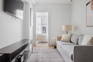 a living room with a couch and a tv at Blueground Upper East Side AC wd nr park NYC-1747 in New York