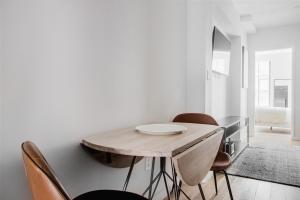 a dining room with a wooden table and chairs at Blueground Upper East Side AC wd nr park NYC-1747 in New York +10 photos