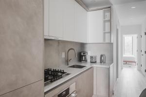 a kitchen with a sink and a stove top oven at Blueground Upper East Side AC wd nr park NYC-1747 in New York