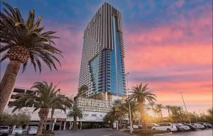 a tall building with palm trees in front of a parking lot at 37th FLOOR STUDIO STRIP VIEW Palm Place Resort in Las Vegas