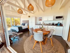 a kitchen and living room with a table and chairs at Sea Views, Hikes & Tranquility Wildside Cabin in Plettenberg Bay