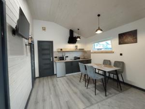 a kitchen and dining room with a table and chairs at Family House Volosianka in Volosyanka
