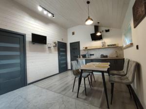 a kitchen with a table and chairs in a room at Family House Volosianka in Volosyanka