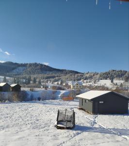 a pair of chairs sitting in the snow at Family House Volosianka in Volosyanka