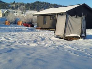 a tent in the snow in front of a house at Family House Volosianka in Volosyanka