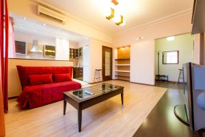 a living room with a red couch and a glass table at Five Stars Revolution square in Chelyabinsk