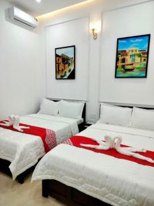 - une chambre avec 2 lits et des couvertures rouges et blanches dans l'établissement Cosy Homestay Huế, à Hue