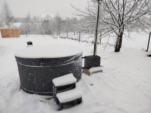 a snow covered area with a trash can and benches at Family House Volosianka in Volosyanka