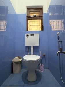 bagno blu con servizi igienici e finestra di DRAKON NEST HOMESTAY a Kathmandu