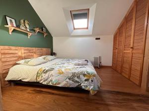 a bedroom with a bed with a wooden headboard at Le Loft in Lacanau
